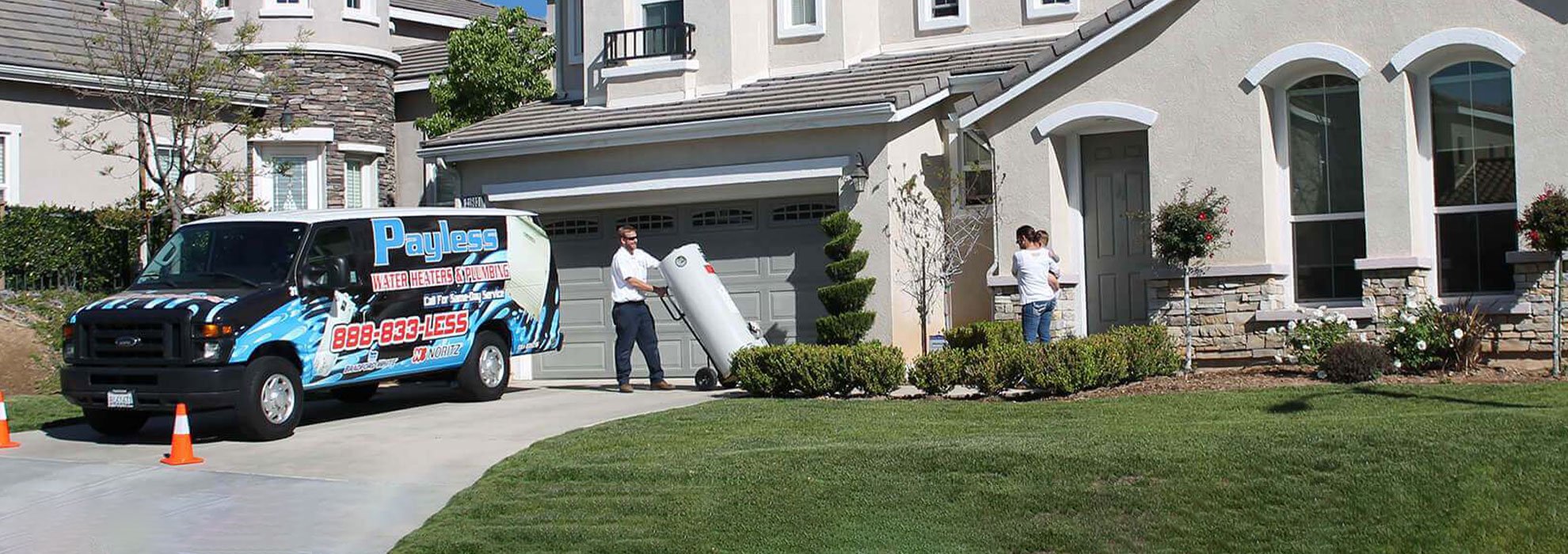 Payless truck in a driveway while technician walks water heater to the door.